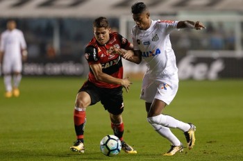 Cuéllar, do Flamengo, e Bruno Henrique, do Santos, lutam por posse da bola durante jogo entre as eq
